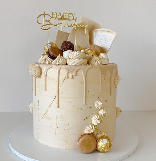 Multi-tiered celebration cake with elegant floral decorations and smooth fondant finish